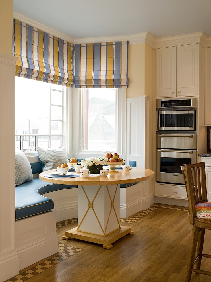Inspiration for a large traditional kitchen/dining combo in San Francisco with yellow walls, medium hardwood floors and brown floor.