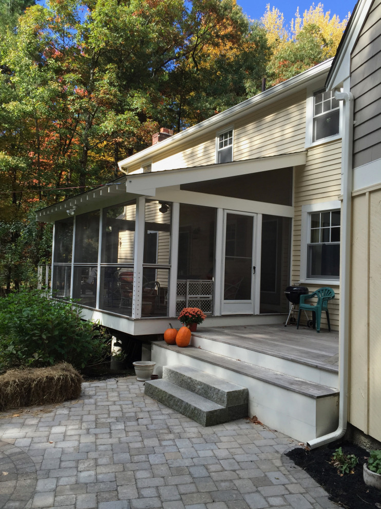 Ejemplo de porche cerrado clásico renovado de tamaño medio en patio trasero con adoquines de hormigón y barandilla de cable