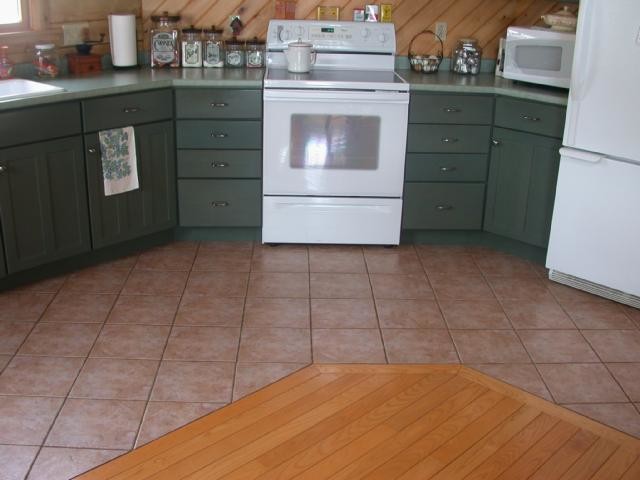 Transitional kitchen photo with a drop-in sink, green cabinets, white appliances and no island