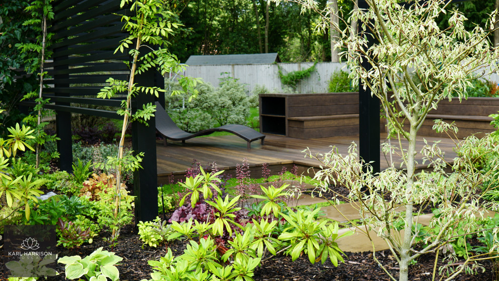Foto di un grande giardino minimalista esposto in pieno sole dietro casa in estate con pedane e recinzione in legno