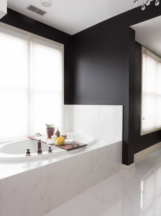 Photo of a mid-sized transitional master bathroom in Chicago with beaded inset cabinets, medium wood cabinets, a drop-in tub, an alcove shower, a one-piece toilet, black and white tile, porcelain tile, black walls, marble floors, an undermount sink and marble benchtops.