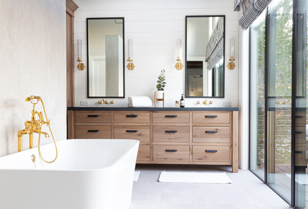 Large country master bathroom in San Francisco with flat-panel cabinets, light wood cabinets, a freestanding tub, white walls, porcelain floors, granite benchtops, grey floor, black benchtops, a double vanity, a freestanding vanity and planked wall panelling.