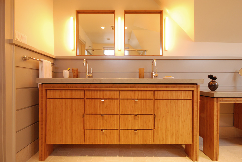 This is an example of a mid-sized modern master bathroom in Boston with medium wood cabinets, a freestanding tub, gray tile, cement tile, an undermount sink, concrete benchtops, furniture-like cabinets, a corner shower, a two-piece toilet, grey walls, limestone floors, a hinged shower door and grey benchtops.