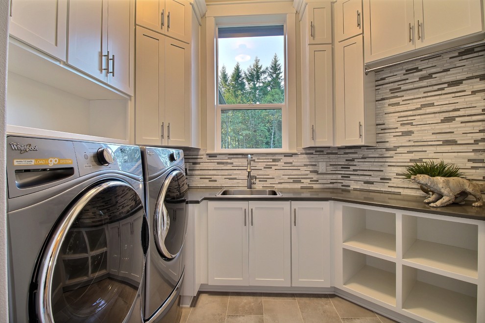 Photo of a large transitional u-shaped utility room in Portland with a drop-in sink, recessed-panel cabinets, white cabinets, quartzite benchtops, multi-coloured walls, travertine floors and a side-by-side washer and dryer.