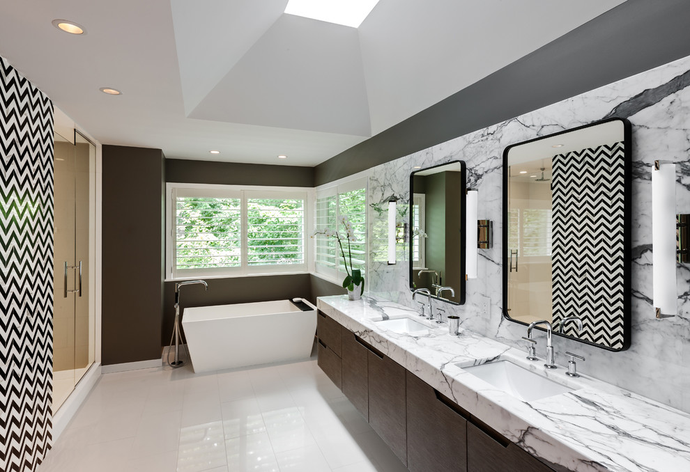 This is an example of a contemporary bathroom in Minneapolis with a freestanding tub, marble benchtops and marble.
