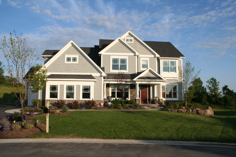 This is an example of a large traditional two-storey grey exterior in New York with mixed siding and a gable roof.