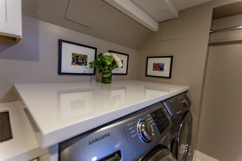 Large traditional single-wall dedicated laundry room in Minneapolis with an undermount sink, beaded inset cabinets, white cabinets, marble benchtops, beige walls, vinyl floors, a side-by-side washer and dryer, beige floor and white benchtop.