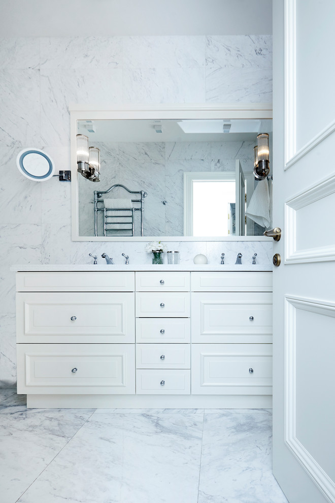 Photo of a mid-sized transitional bathroom in Moscow with an undermount tub, an alcove shower, a wall-mount toilet, white tile, marble, white walls, marble floors, an undermount sink, marble benchtops, white floor and a hinged shower door.