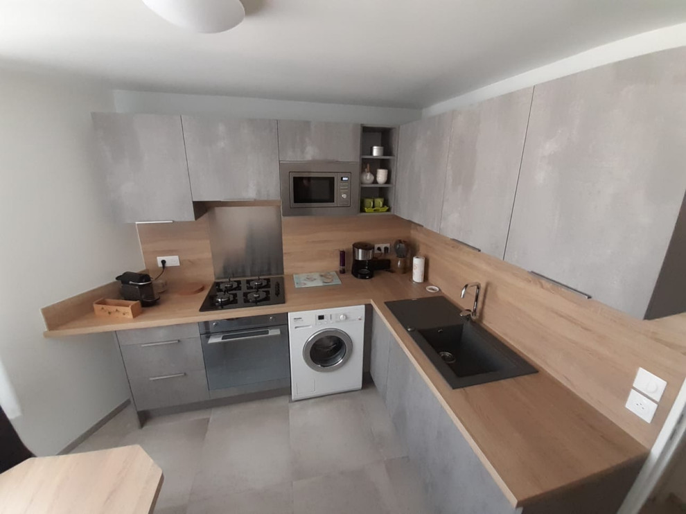 Foto di una cucina minimalista chiusa e di medie dimensioni con ante grigie, top in legno, paraspruzzi in legno, pavimento grigio, lavello a vasca singola e elettrodomestici da incasso