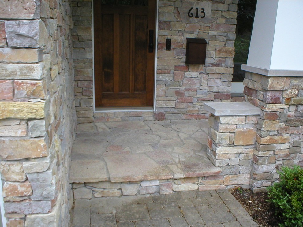 Photo of a small traditional front yard verandah in Chicago with natural stone pavers.