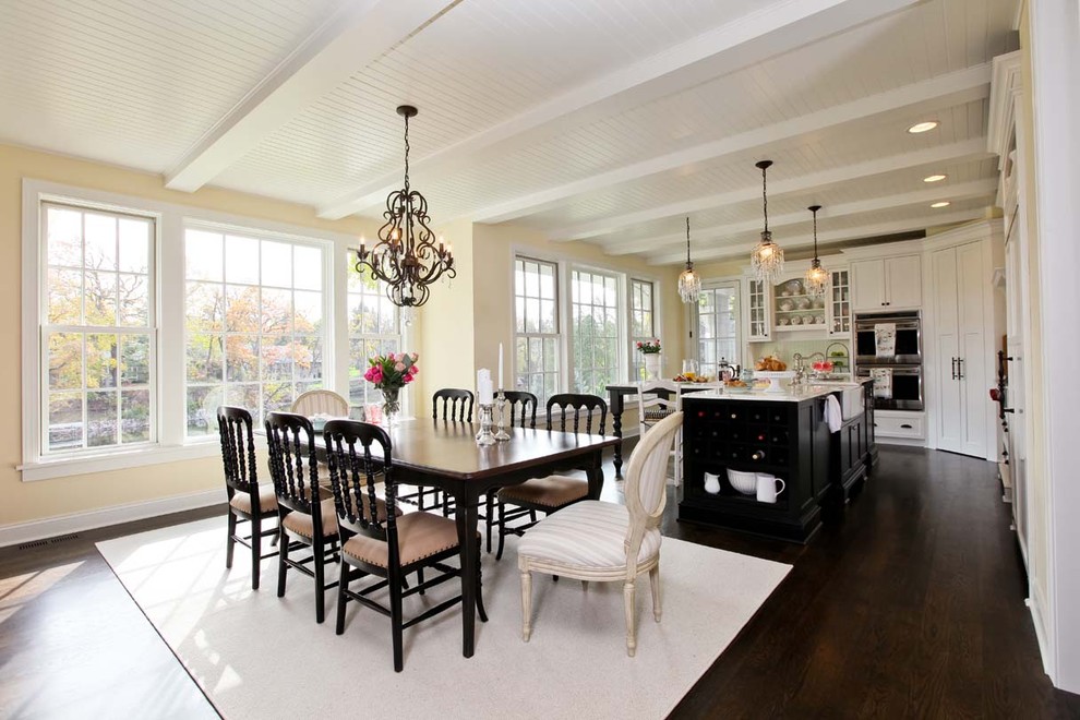 This is an example of a traditional kitchen/dining combo in Minneapolis with beige walls and dark hardwood floors.