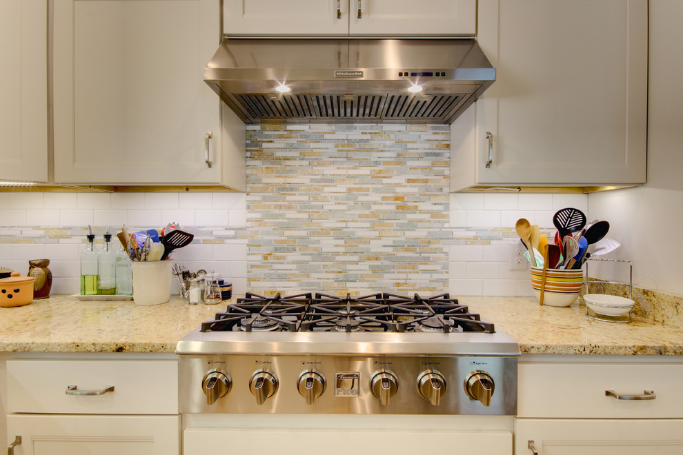 Eat-in kitchen - mid-sized transitional u-shaped vinyl floor eat-in kitchen idea in Miami with an undermount sink, shaker cabinets, white cabinets, granite countertops, white backsplash, subway tile backsplash, stainless steel appliances and an island