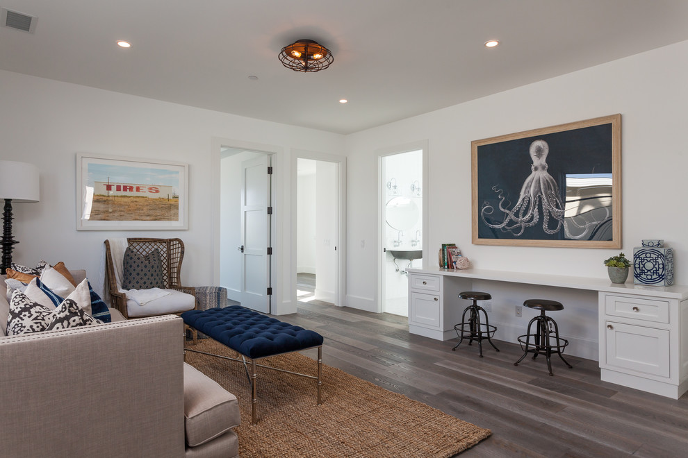 This is an example of a beach style home office in Orange County with white walls and dark hardwood floors.