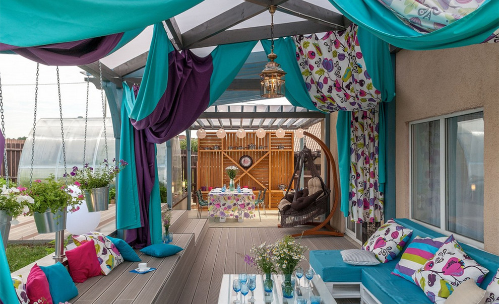 This is an example of an eclectic backyard deck in Moscow with a pergola.