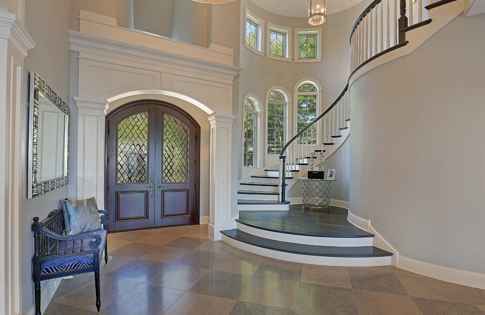 This is an example of a large traditional foyer in Chicago with blue walls, travertine floors, a double front door and a dark wood front door.