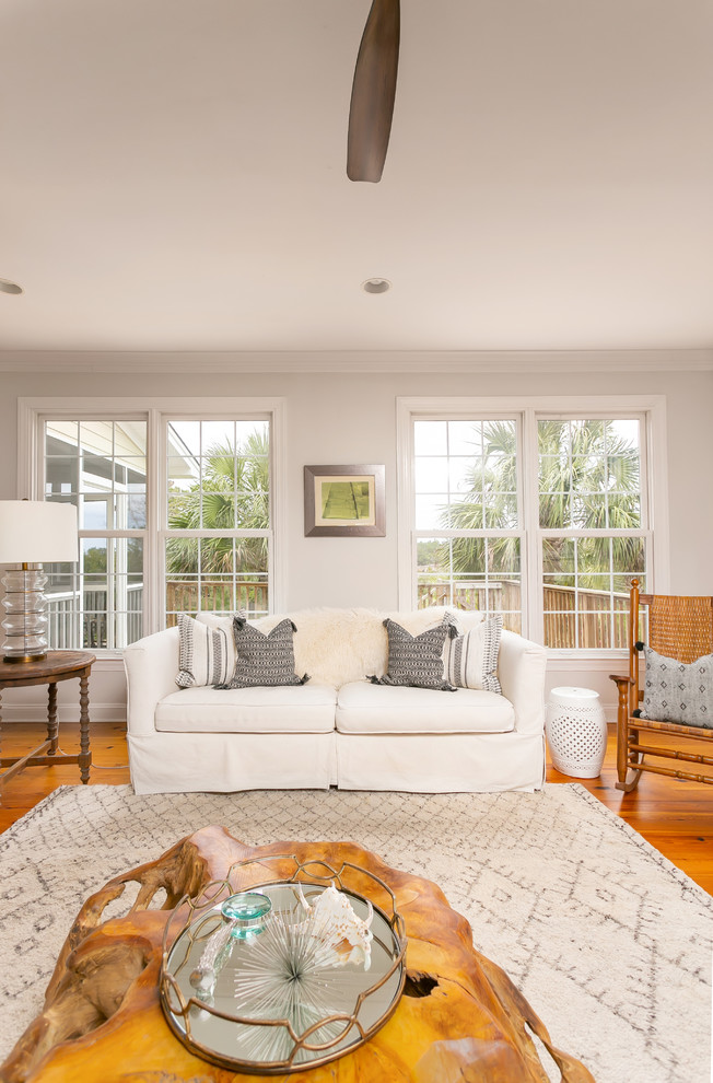 Large beach style open concept living room in Charleston with white walls, light hardwood floors, a standard fireplace, a tile fireplace surround, a wall-mounted tv and brown floor.