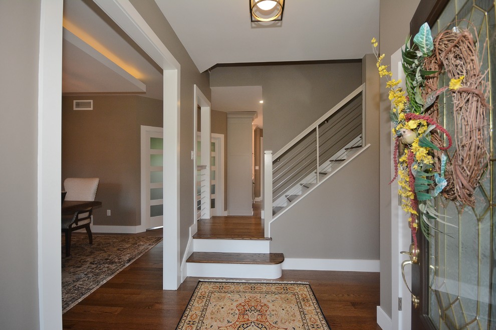 This is an example of a mid-sized transitional wood straight staircase in Other with painted wood risers and cable railing.