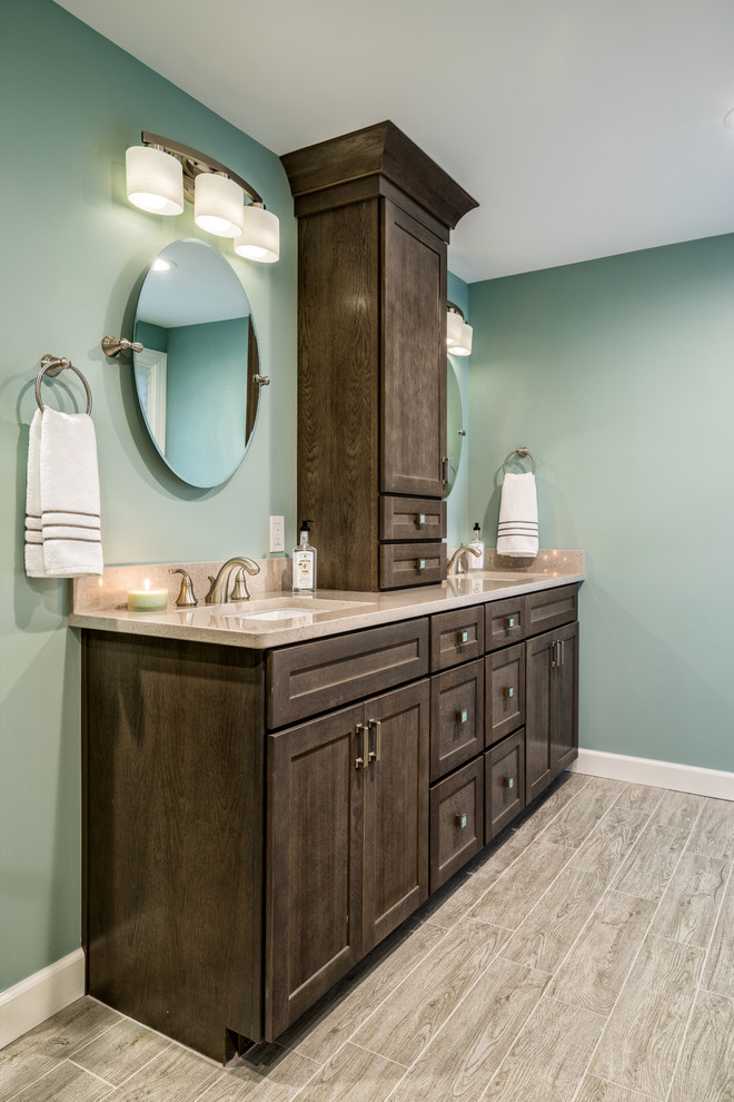 Inspiration for a large transitional master bathroom in Detroit with shaker cabinets, dark wood cabinets, a curbless shower, blue walls, medium hardwood floors, an undermount sink, engineered quartz benchtops, grey floor, a hinged shower door, beige tile and porcelain tile.