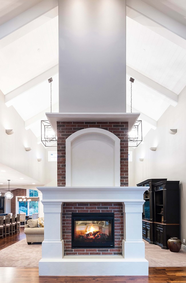 Design ideas for a large transitional formal open concept living room in Salt Lake City with white walls, carpet, a two-sided fireplace, a brick fireplace surround, a freestanding tv and beige floor.