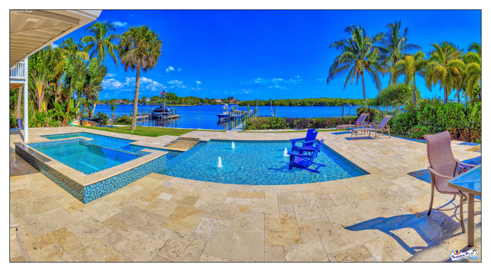 Expansive modern courtyard custom-shaped lap pool in Tampa with a pool house and natural stone pavers.