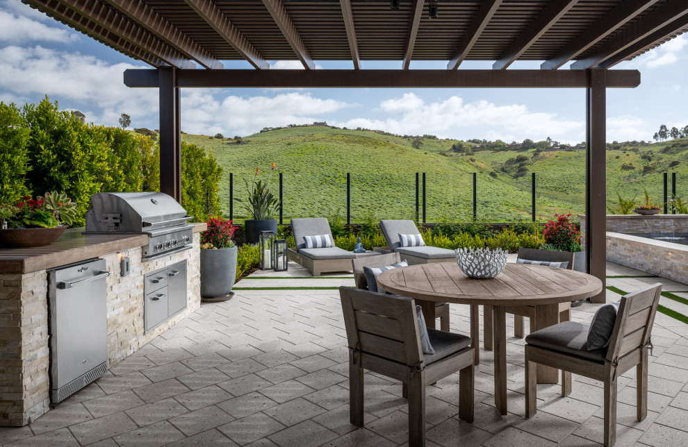 Transitional patio in Los Angeles with an outdoor kitchen and a pergola.