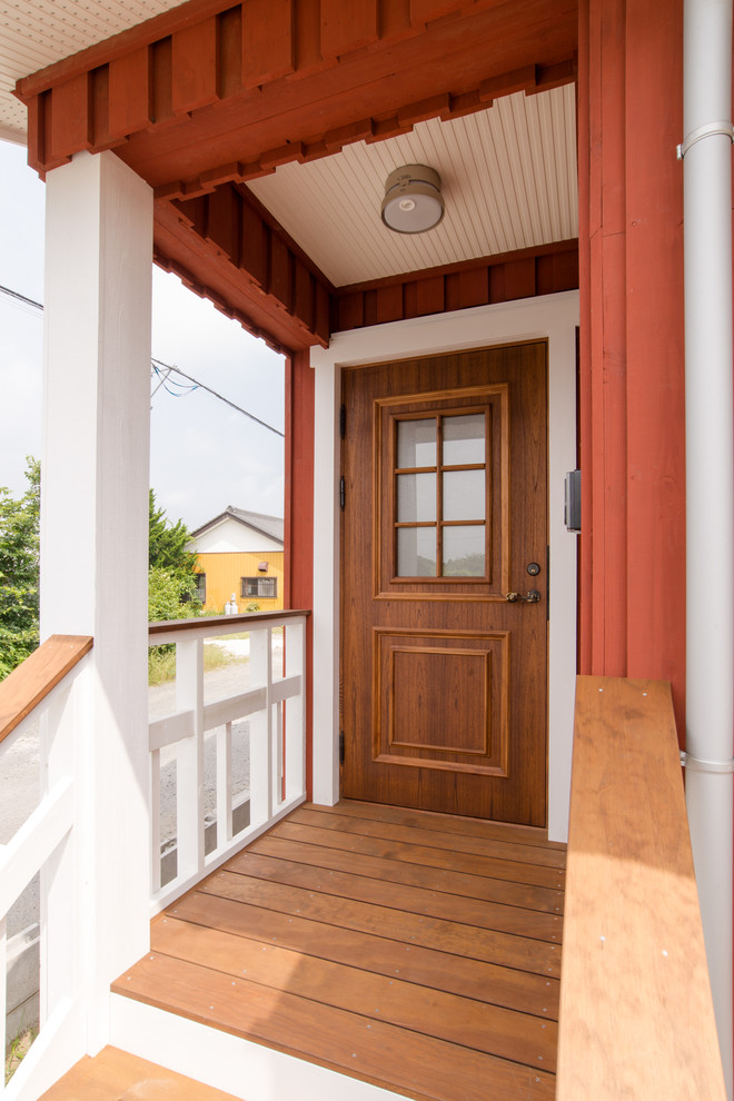 Small scandinavian front door in Other with red walls, medium hardwood floors, a single front door, a medium wood front door and brown floor.