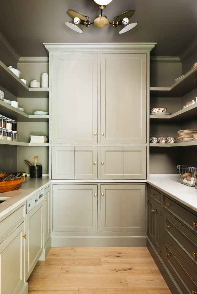 Inspiration for a transitional u-shaped kitchen pantry in Grand Rapids with recessed-panel cabinets, green cabinets, marble benchtops, light hardwood floors, beige floor and white benchtop.