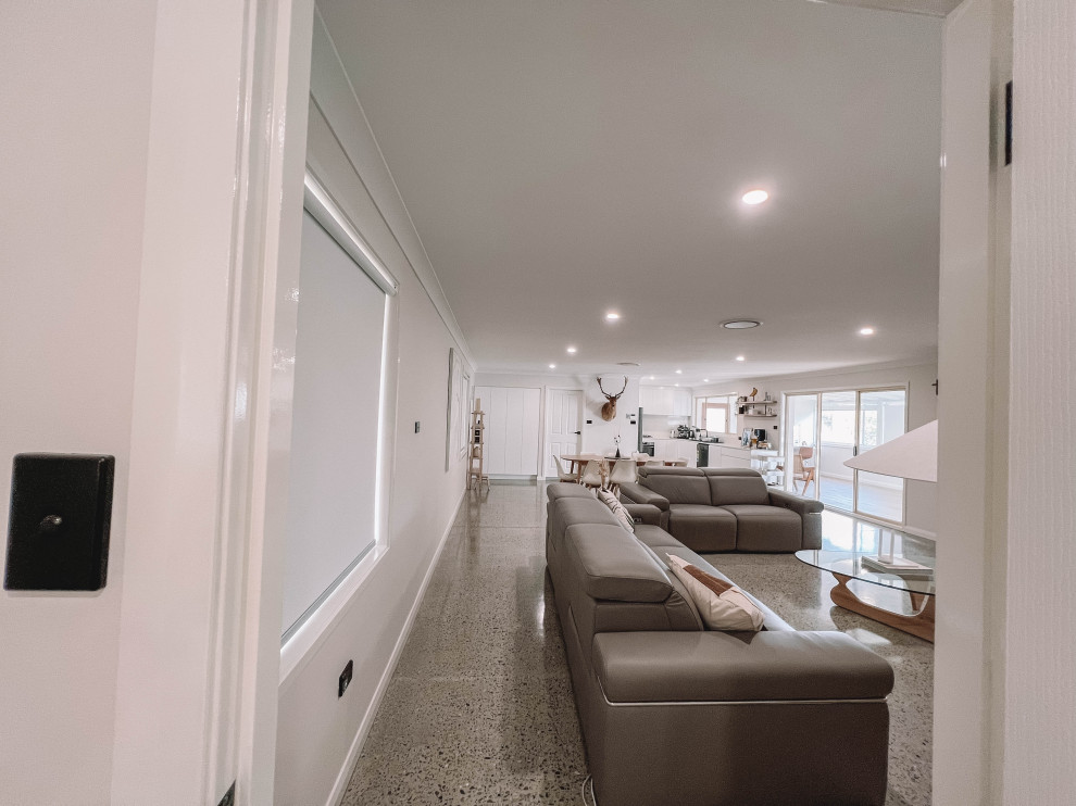 Immagine di un soggiorno nordico di medie dimensioni e aperto con pareti bianche, pavimento in cemento, TV autoportante, pavimento grigio, soffitto in legno e pareti in legno