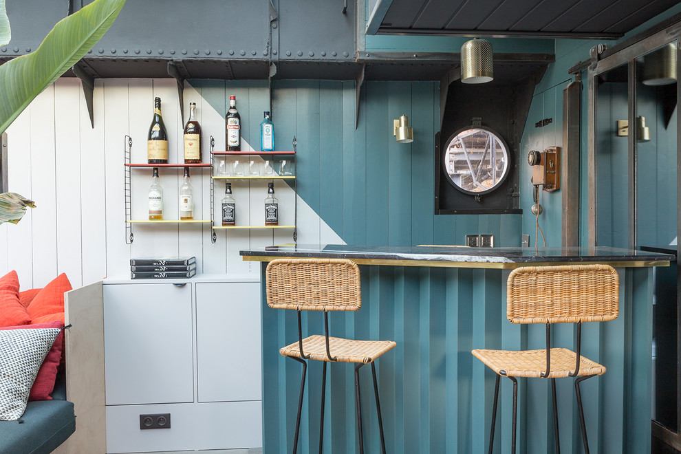 This is an example of a beach style seated home bar in Paris with flat-panel cabinets and white cabinets.