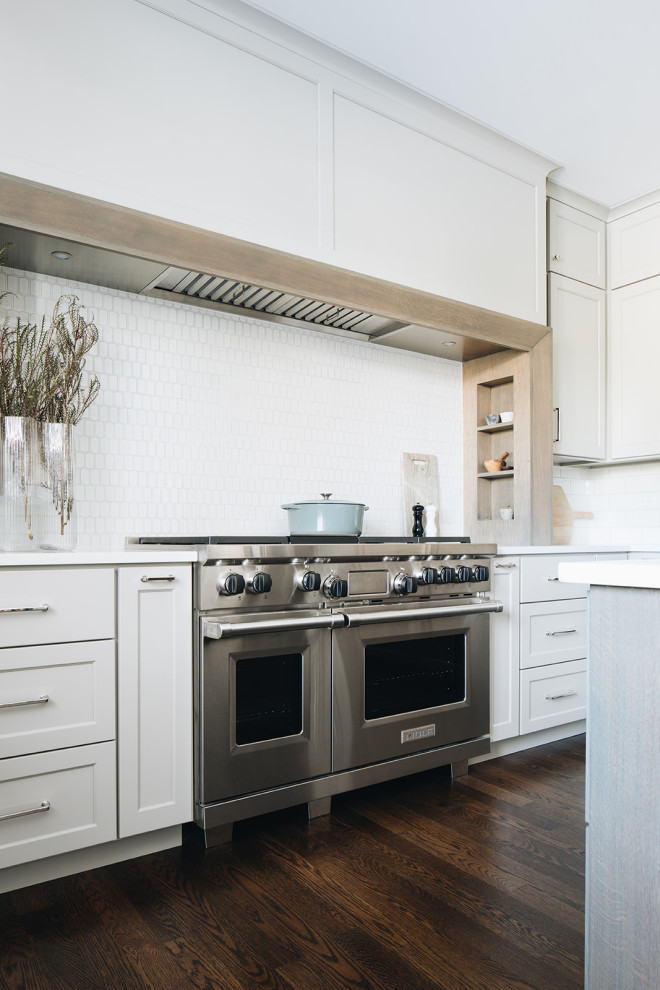 Eat-in kitchen - mid-sized transitional dark wood floor eat-in kitchen idea in Chicago with a farmhouse sink, shaker cabinets, gray cabinets, quartz countertops, white backsplash, ceramic backsplash, paneled appliances, an island and white countertops