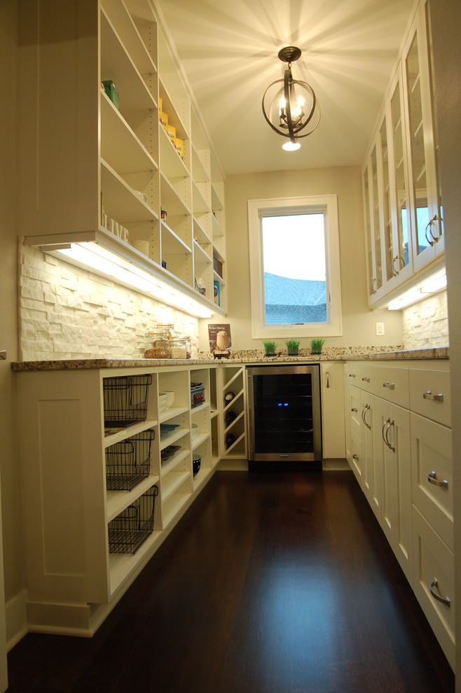 Inspiration for a small transitional galley dark wood floor kitchen pantry remodel with an undermount sink, shaker cabinets, white cabinets, granite countertops, white backsplash, stone tile backsplash, stainless steel appliances, gray walls and no island