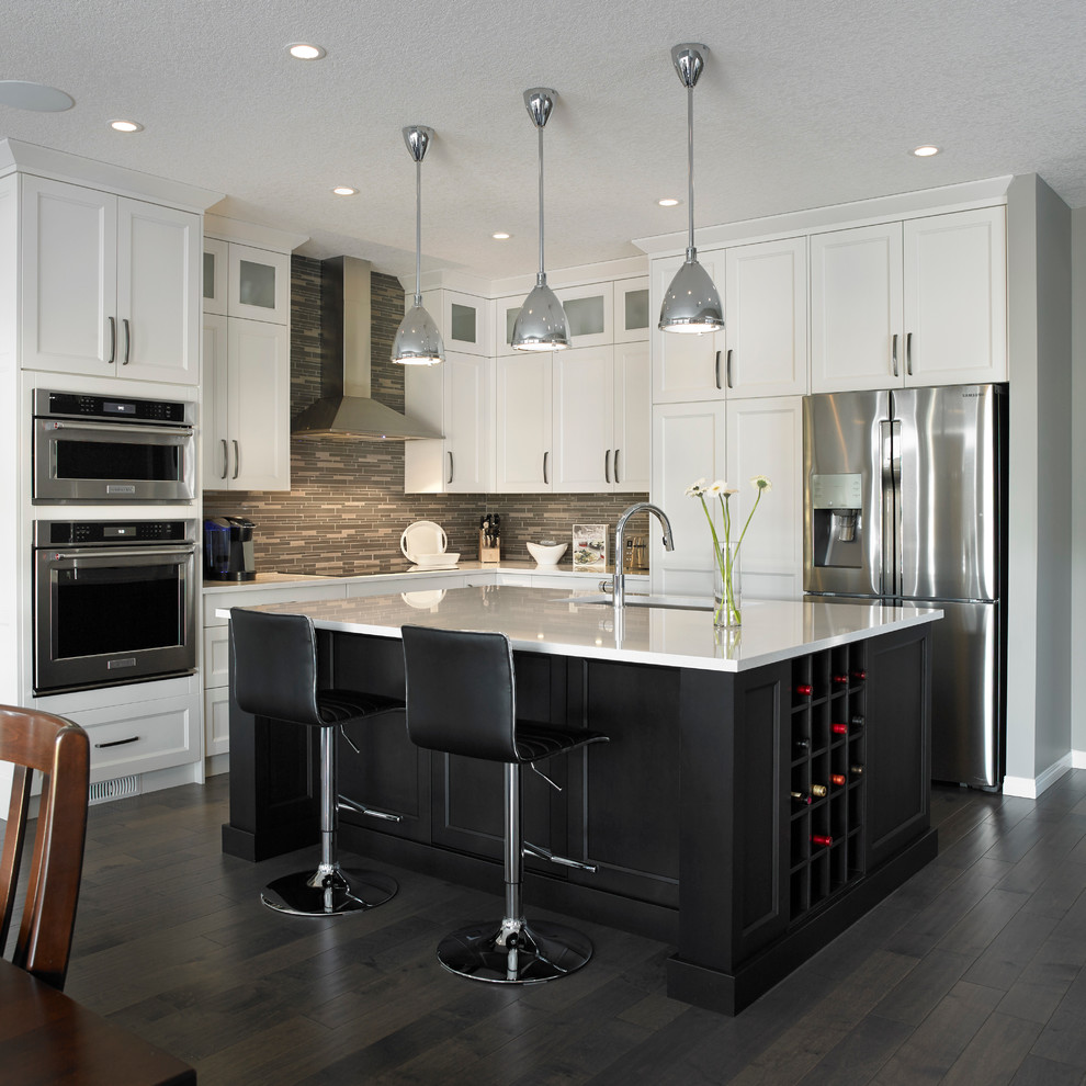 Inspiration for a mid-sized transitional l-shaped dark wood floor eat-in kitchen remodel in Calgary with an undermount sink, white cabinets, multicolored backsplash, stainless steel appliances, an island, shaker cabinets, quartzite countertops and matchstick tile backsplash