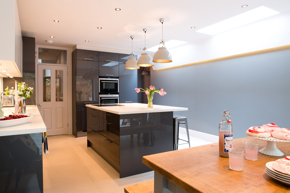 Mid-sized contemporary single-wall eat-in kitchen in Kent with flat-panel cabinets, grey cabinets, white splashback, with island and white floor.