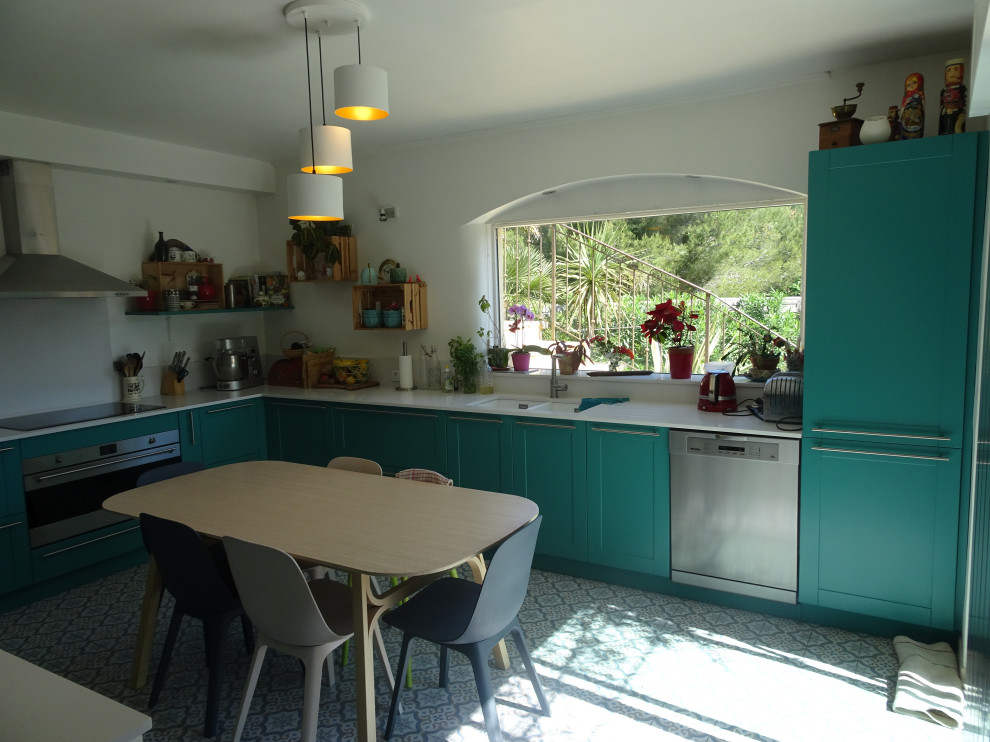 Photo of a large classic l-shaped kitchen in Marseille with a submerged sink, recessed-panel cabinets, turquoise cabinets, quartz worktops, white splashback, stainless steel appliances, cement flooring, no island, blue floors and white worktops.
