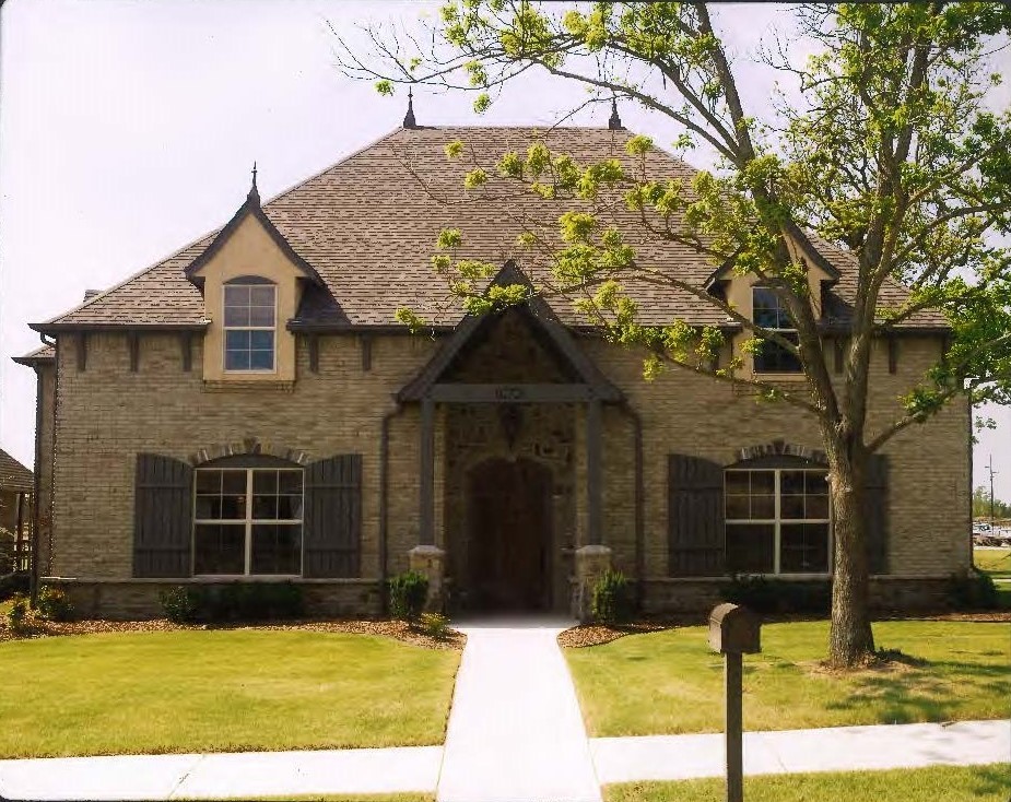 This is an example of a mid-sized country two-storey brick beige exterior in Oklahoma City with a hip roof.