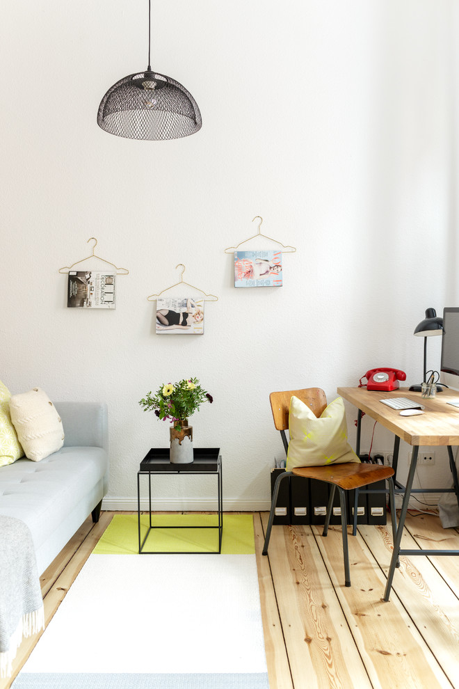 Inspiration for a small scandinavian home office in Berlin with white walls, light hardwood floors and no fireplace.