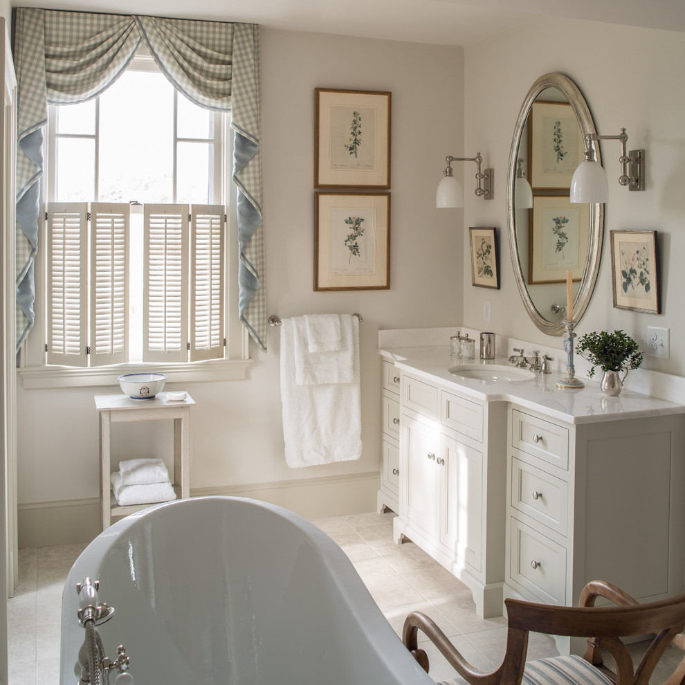 Traditional bathroom in Baltimore with an undermount sink, a freestanding tub, beige tile and beige walls.