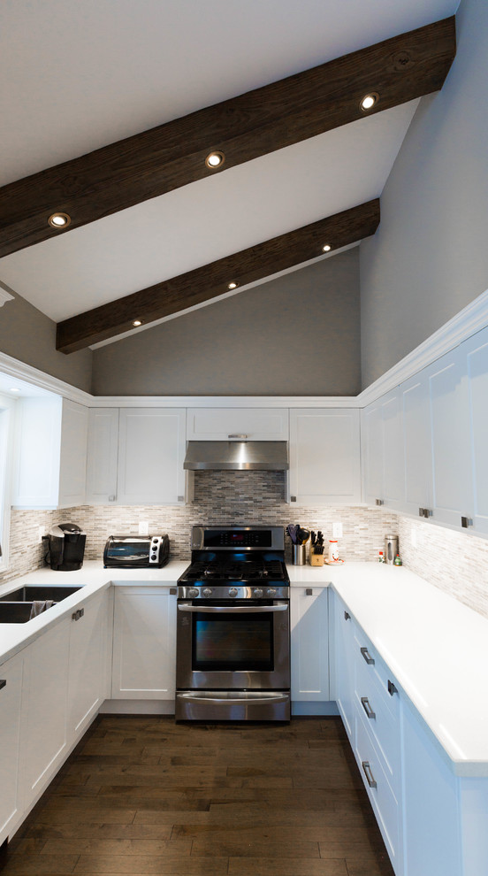 Example of a mid-sized transitional u-shaped medium tone wood floor and brown floor open concept kitchen design in Toronto with a double-bowl sink, recessed-panel cabinets, white cabinets, quartz countertops, gray backsplash, marble backsplash, stainless steel appliances, no island and white countertops