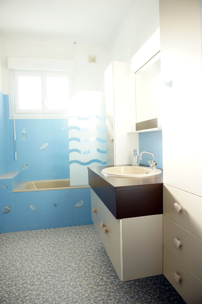 Large beach style master bathroom in Rennes with an undermount tub, blue tile, blue walls, linoleum floors and an undermount sink.