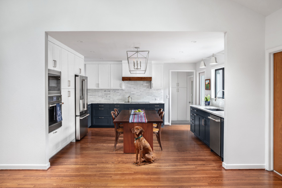 Inspiration for a mid-sized transitional u-shaped medium tone wood floor and brown floor eat-in kitchen remodel in Austin with a single-bowl sink, shaker cabinets, blue cabinets, quartzite countertops, gray backsplash, marble backsplash, stainless steel appliances, no island and gray countertops