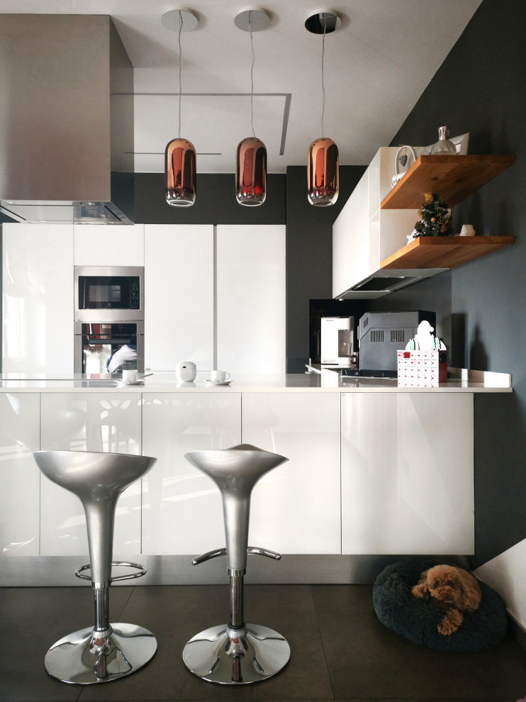 Inspiration för stora moderna vitt kök, med en nedsänkt diskho, luckor med glaspanel, vita skåp, bänkskiva i glas, grått stänkskydd, klinkergolv i porslin, en halv köksö och grått golv
