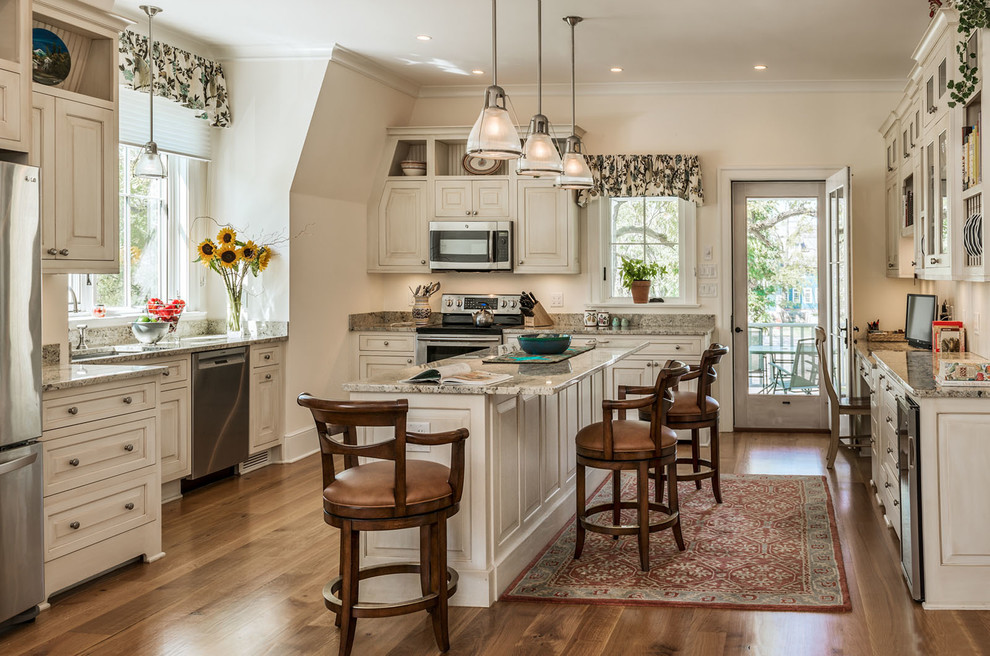 This is an example of a country kitchen in New York with raised-panel cabinets, white cabinets, stainless steel appliances, dark hardwood floors and with island.