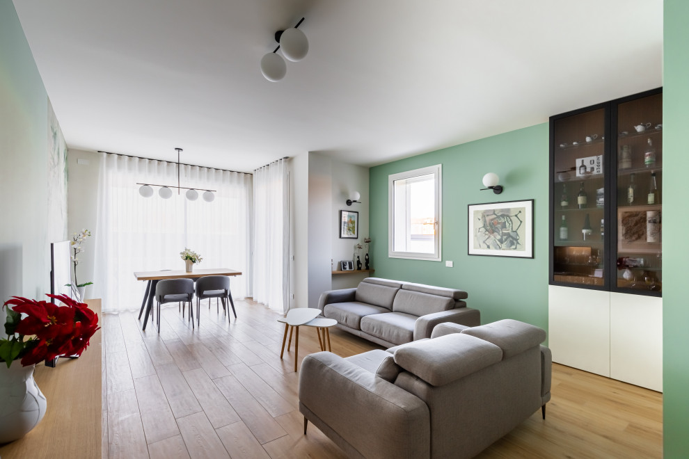 Cette image montre un très grand salon design fermé avec un bar de salon, un mur vert, un sol en carrelage de porcelaine, un téléviseur fixé au mur et du papier peint.