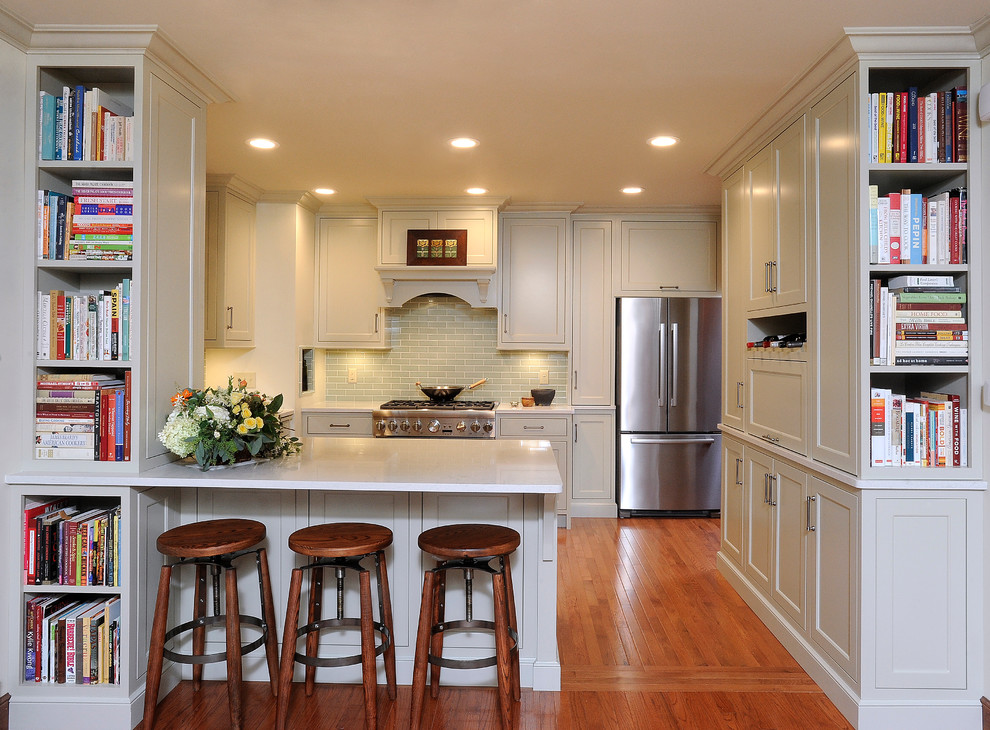 Eat-in kitchen - small transitional u-shaped medium tone wood floor eat-in kitchen idea with an undermount sink, flat-panel cabinets, gray cabinets, quartz countertops, green backsplash, subway tile backsplash, stainless steel appliances and a peninsula