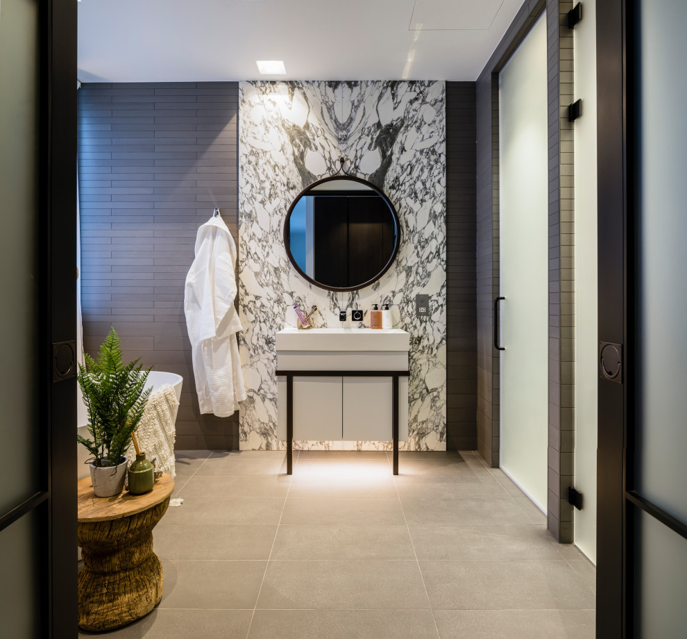 Photo of a contemporary master bathroom in London with flat-panel cabinets, white cabinets, black and white tile, stone slab, grey walls, beige floor, white benchtops, a single vanity and a freestanding vanity.