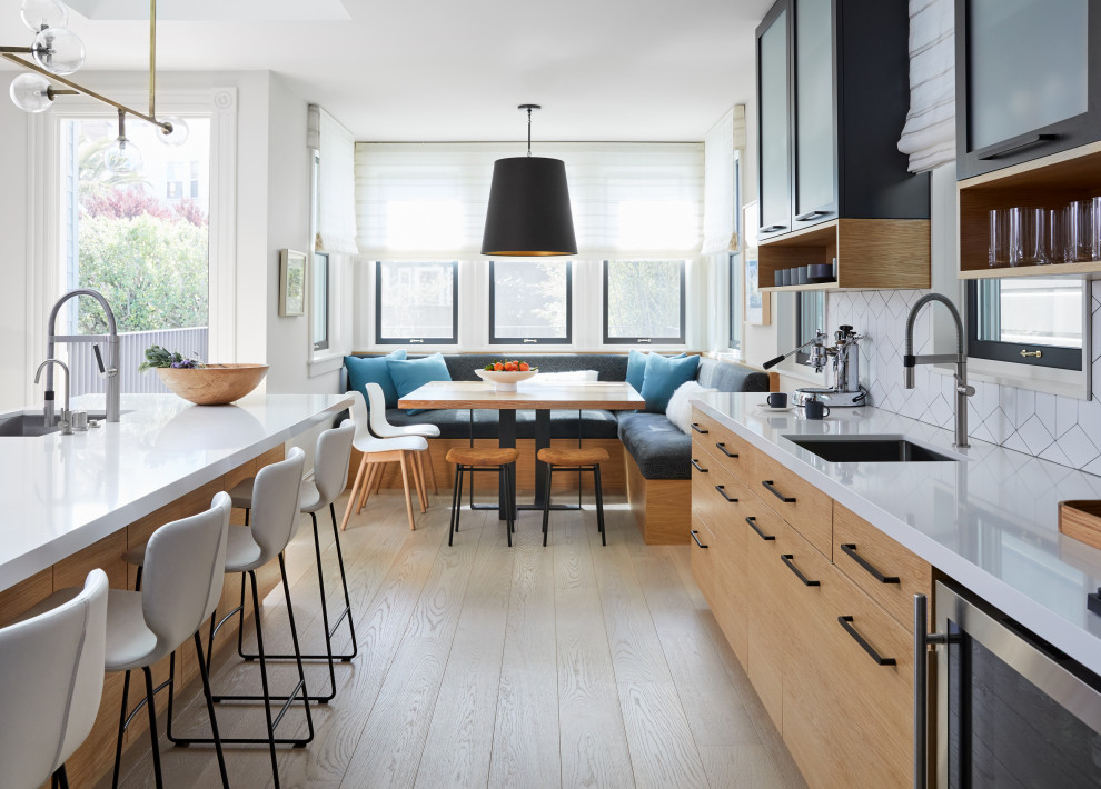 Design ideas for an expansive contemporary galley eat-in kitchen in San Francisco with an undermount sink, flat-panel cabinets, light wood cabinets, quartz benchtops, ceramic splashback, stainless steel appliances, light hardwood floors, with island and white benchtop.