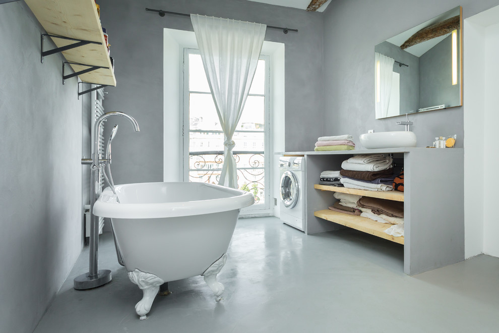 Design ideas for a transitional master bathroom in Nice with a vessel sink, open cabinets, light wood cabinets, a claw-foot tub, grey walls and a laundry.