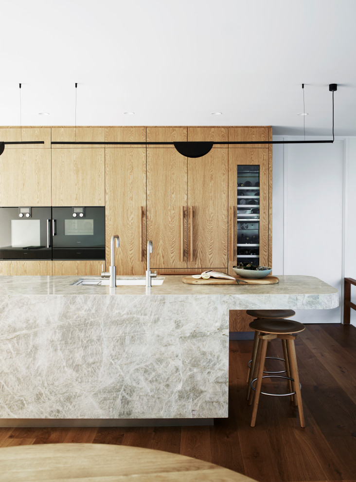 Foto på ett mellanstort 50 tals beige kök, med en undermonterad diskho, bänkskiva i kvartsit, grått stänkskydd, stänkskydd i porslinskakel, svarta vitvaror, mellanmörkt trägolv, en köksö och brunt golv