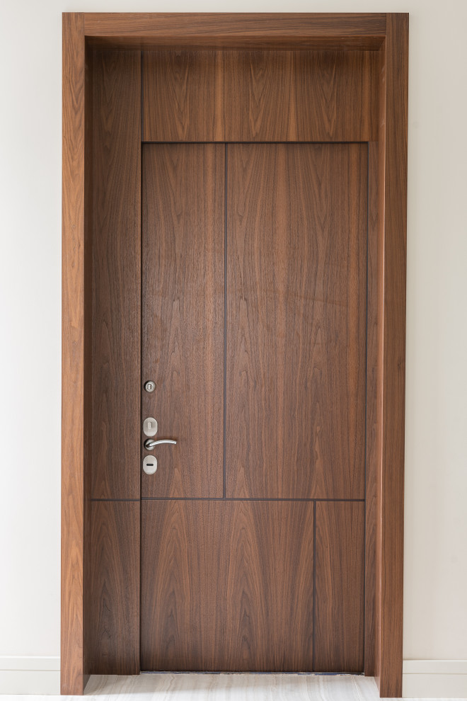 Modelo de entrada actual con paredes beige, puerta simple y puerta de madera en tonos medios