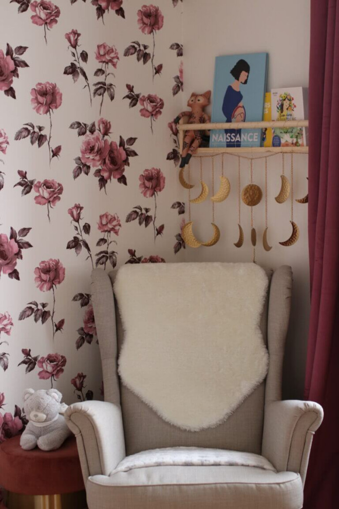 This is an example of a small nursery for girls in Paris with beige walls, laminate floors, beige floor and wallpaper.
